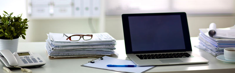 Desk with computer, phone and paperwork