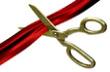 Gold scissors cutting a red ribbon